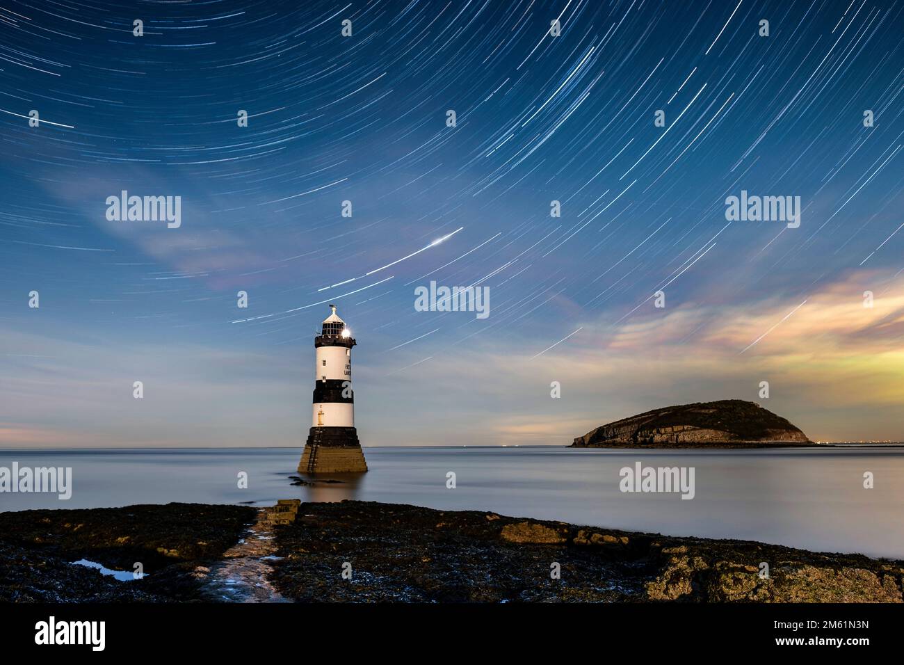 Star Trails su Trwyn Du Lighthouse e Puffin Island, Penmon Point, Anglesey, Galles del Nord, Regno Unito Foto Stock