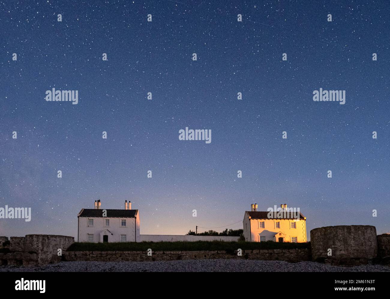 The Night Sky Over the Pilot Cottages, Penmon Point, Anglesey, Galles del Nord, Regno Unito Foto Stock