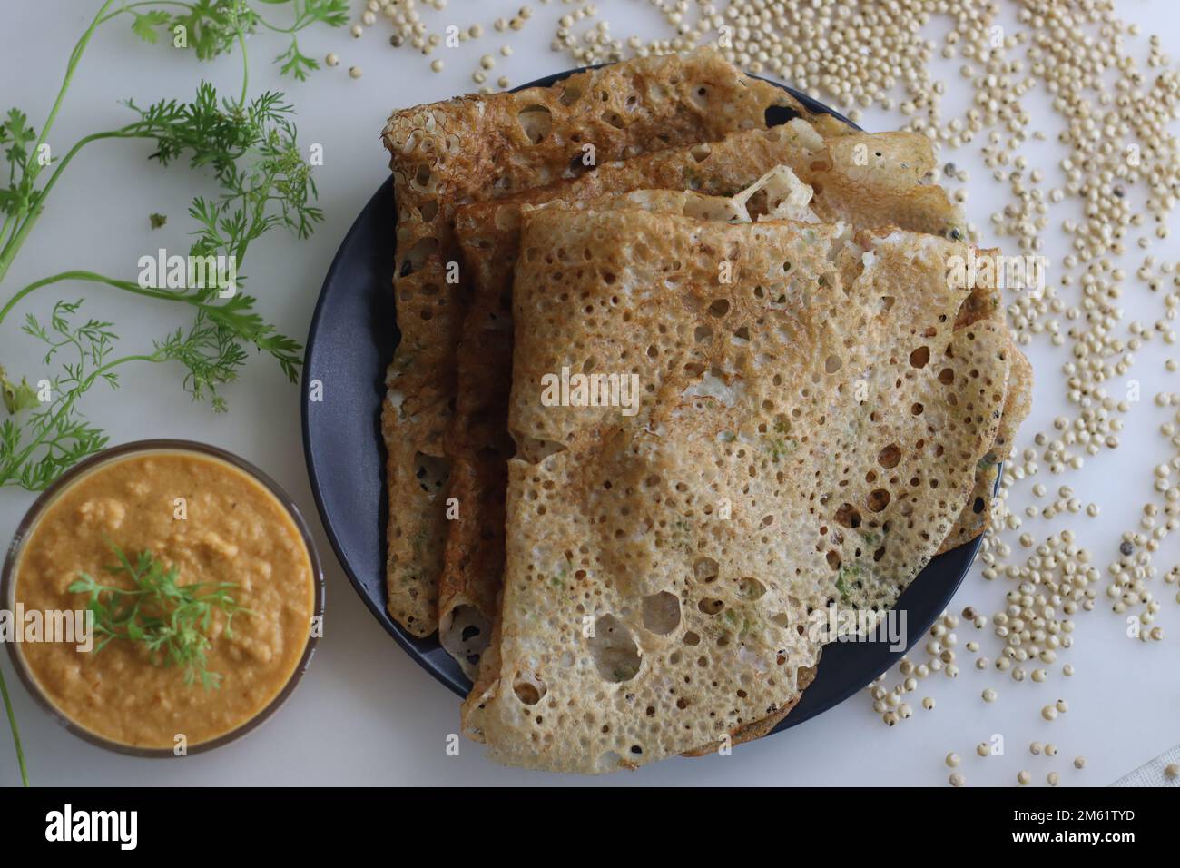 Instant Jowar dosa è un piatto indiano veloce e facile da preparare per la colazione, fatto con farina di jowar mescolandola con acqua e cucinato su una teglia antiaderente preriscaldata. S Foto Stock