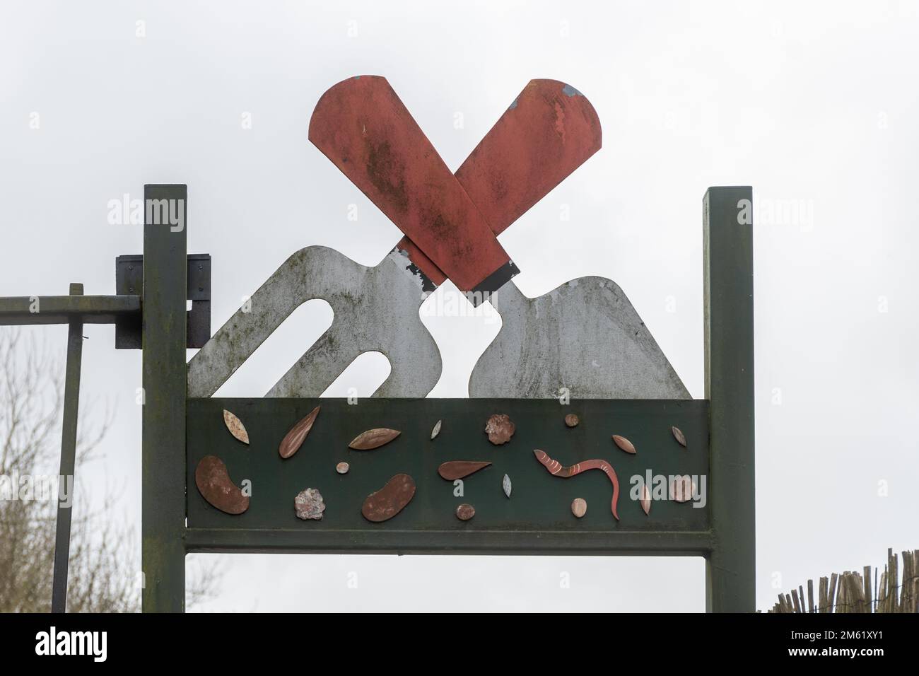 Insolito segno di metallo all'ingresso di allotments con una cazzuola e forchetta, comunità di giardinaggio impianto in Surrey, Inghilterra, Regno Unito Foto Stock