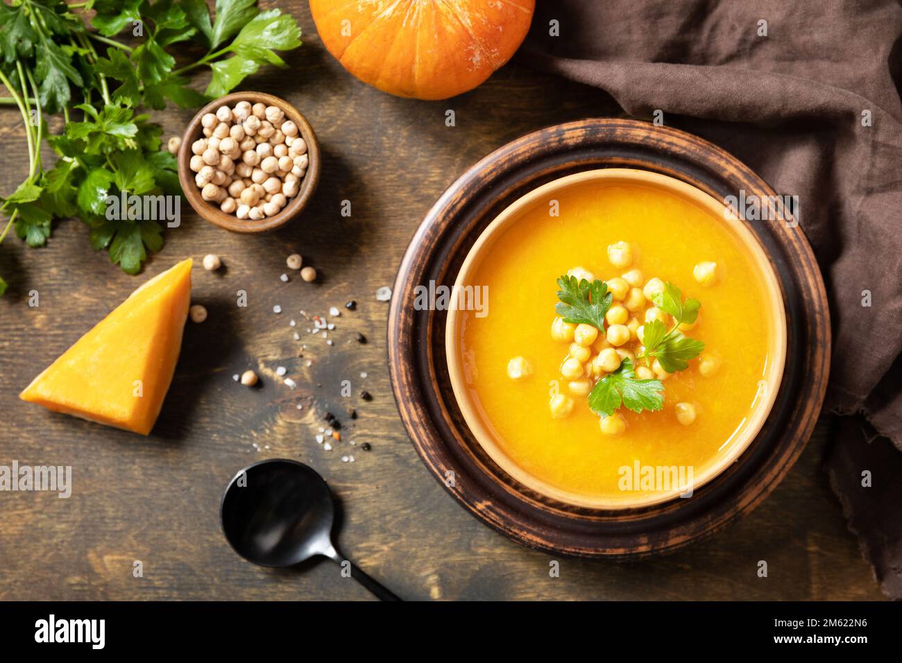 Zuppa vegetariana alla crema di zucca e ceci su un tavolo rustico in legno. Comfort cibo, autunno e inverno sano slow food concetto. Vista dall'alto. Foto Stock