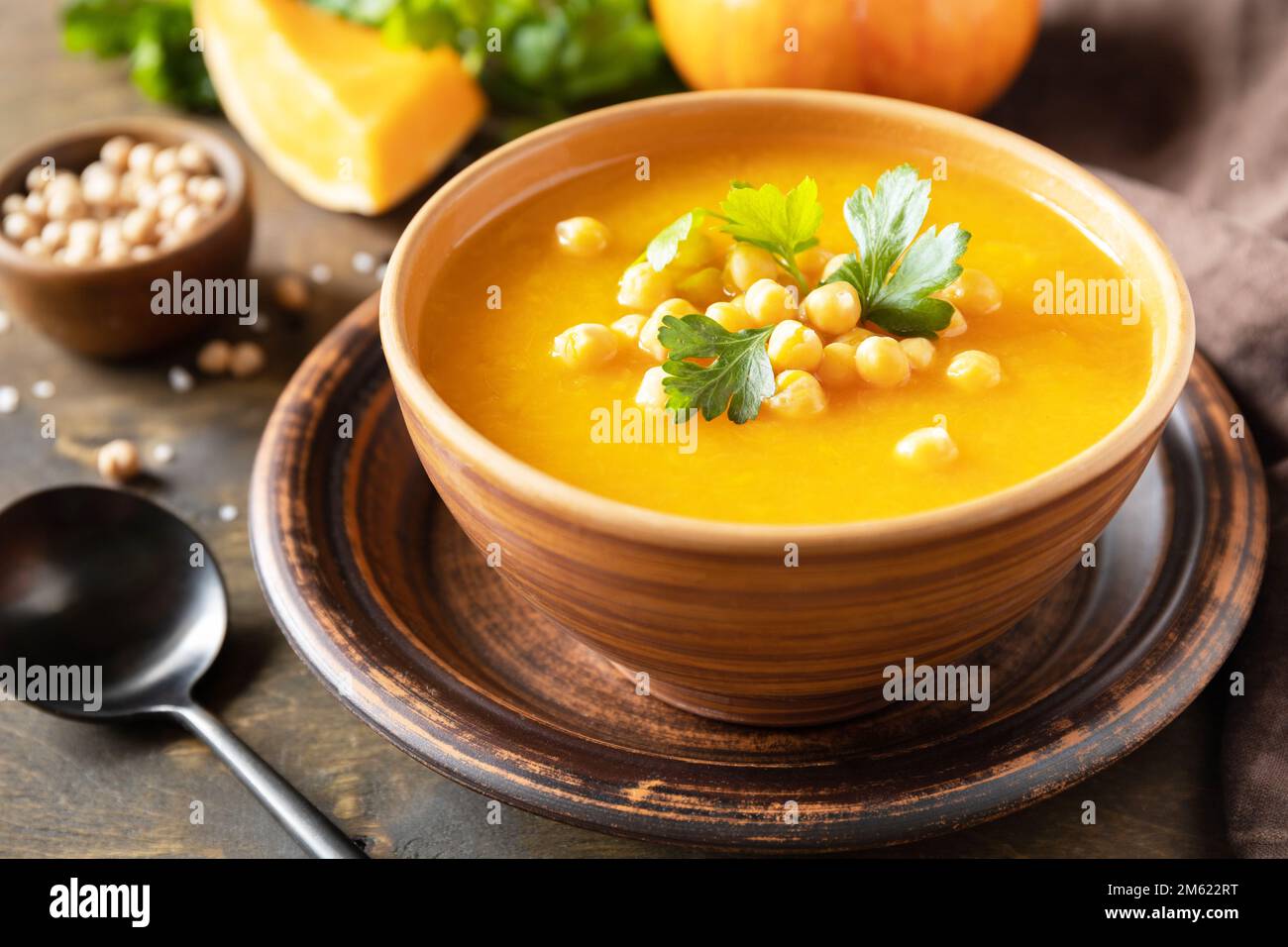 Zuppa vegetariana alla crema di zucca e ceci su un tavolo rustico in legno. Comfort cibo, autunno e inverno sano slow food concetto. Foto Stock