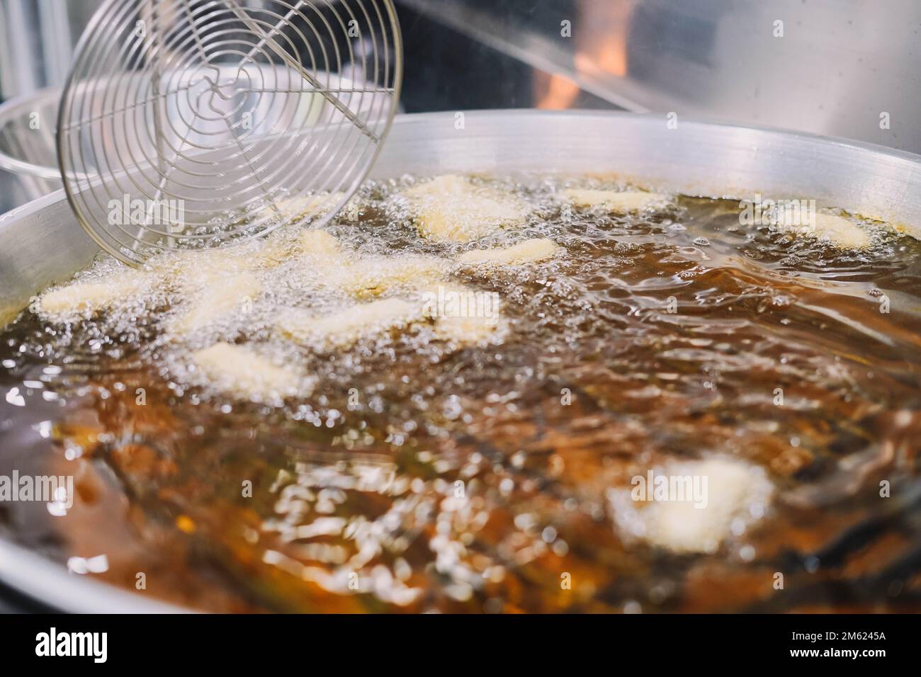 Preparazione di churros fritti con zucchero tipico della Spagna Foto Stock