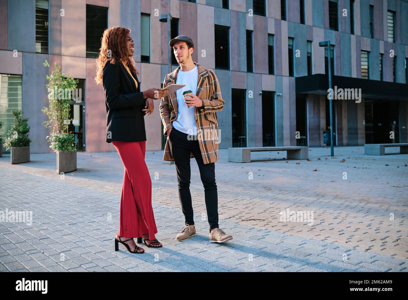 Colleghi aziendali che discutono del lavoro mentre si trovano all'aperto nel quartiere finanziario. Foto Stock