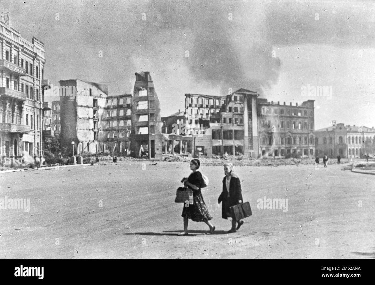Due donne che camminano attraverso una strada nei resti distrutti di Stalingrado durante il WW2 Foto Stock
