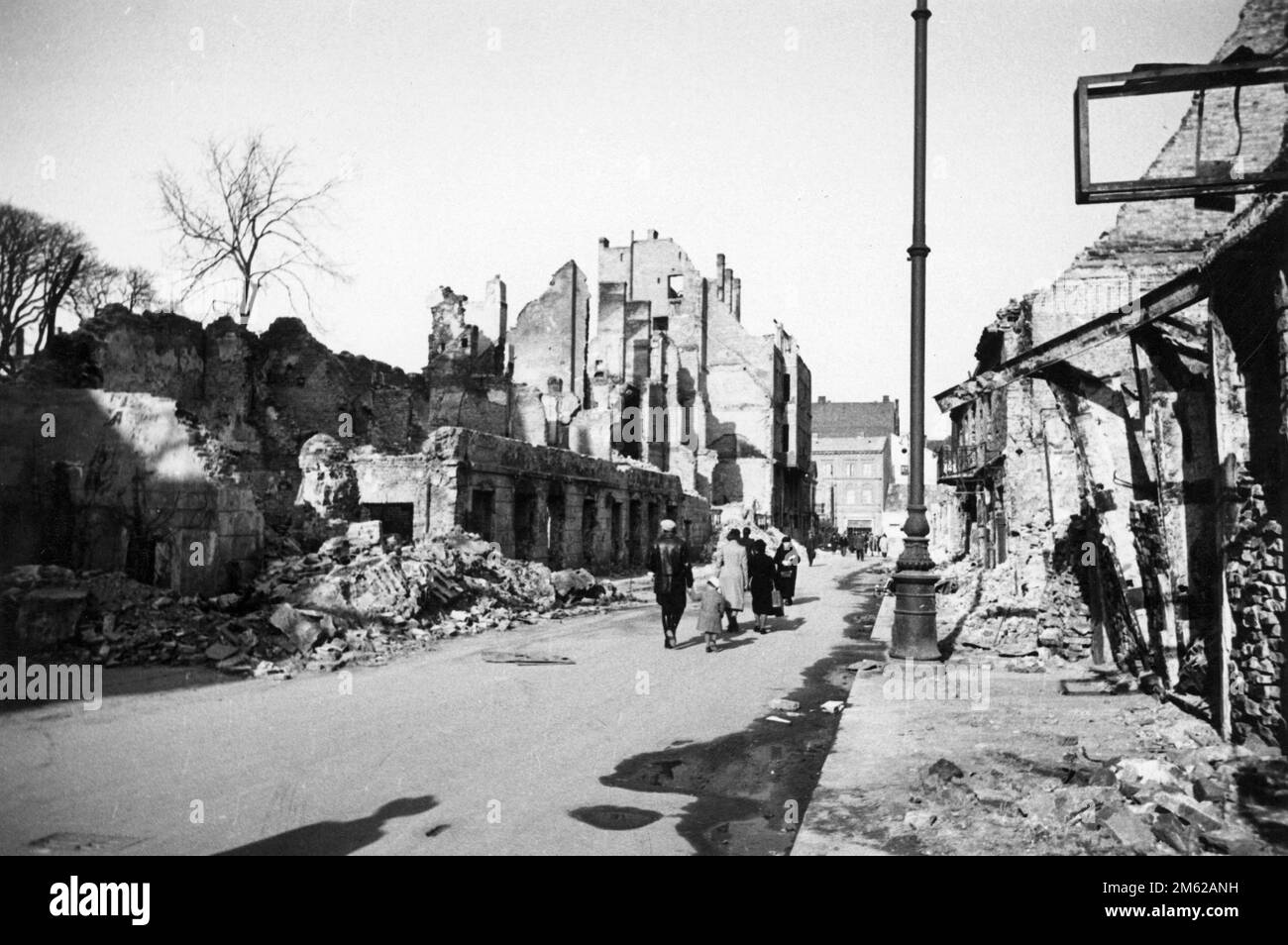 Gli abitanti di Varsavia camminano tra le rovine della loro città dopo l'invasione nazista del 1939. Foto Stock
