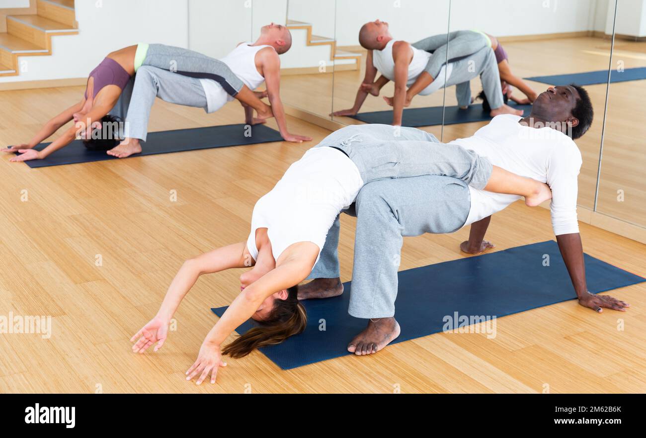 Lezioni di yoga per coppie nel moderno centro fitness Foto Stock