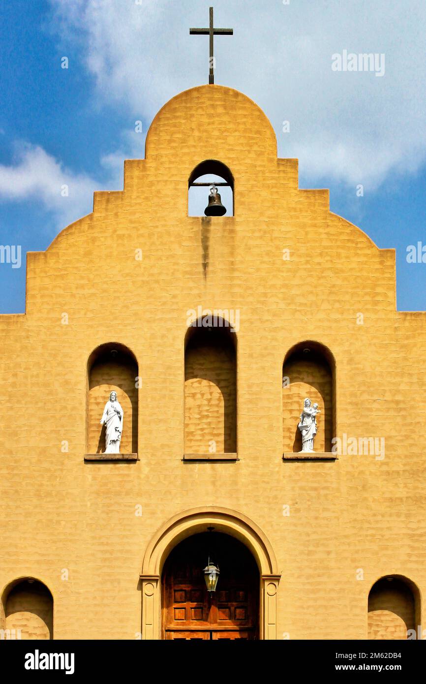 La facciata della Missione Cattolica del buon Pastore a Marietta, Oklahoma, comprende una croce, una campana e statue religiose. Foto Stock