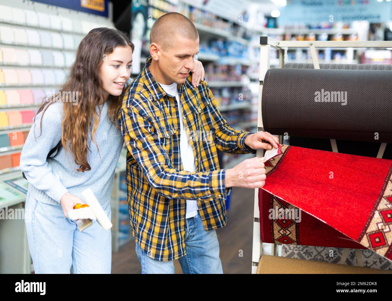 Giovane donna sorridente e uomo che sceglie campioni di pavimenti Foto Stock