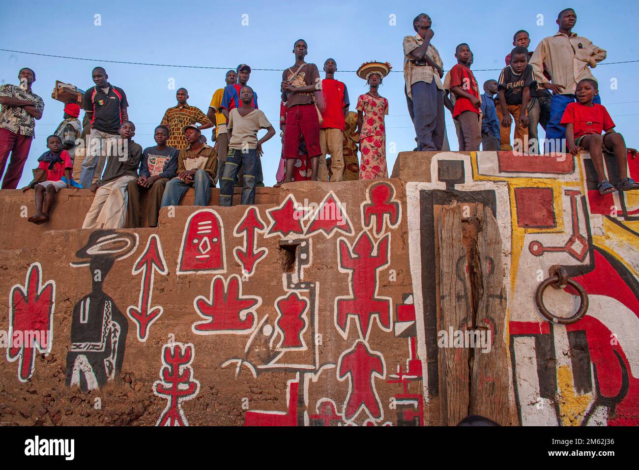 Gruppo di persone con murale d'arte africana a Segou, Mali, Africa occidentale. Foto Stock
