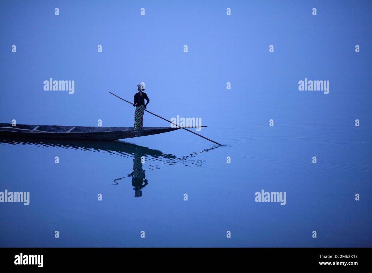 Una giovane donna sbarca la barca di legno sul fiume Niger vicino a Mopti la Venezia dell'Africa, Mali, Africa occidentale. Foto Stock