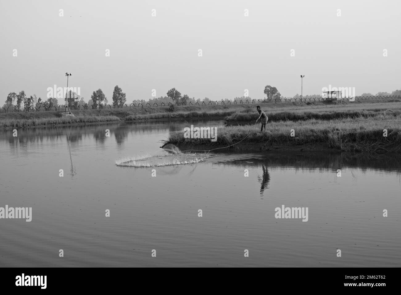 13.11.2022, bengala Occidentale, India. un pescatore indiano solitario in azione su uno stagno. Foto Stock