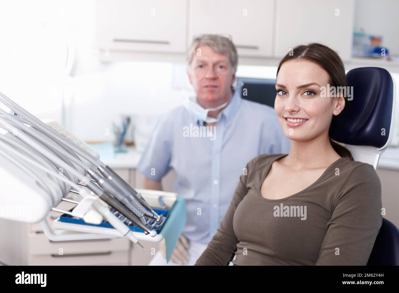 Paziente grazioso con dentista. Ritratto di un paziente giovane e grazioso sorridente con il dentista in clinica. Foto Stock