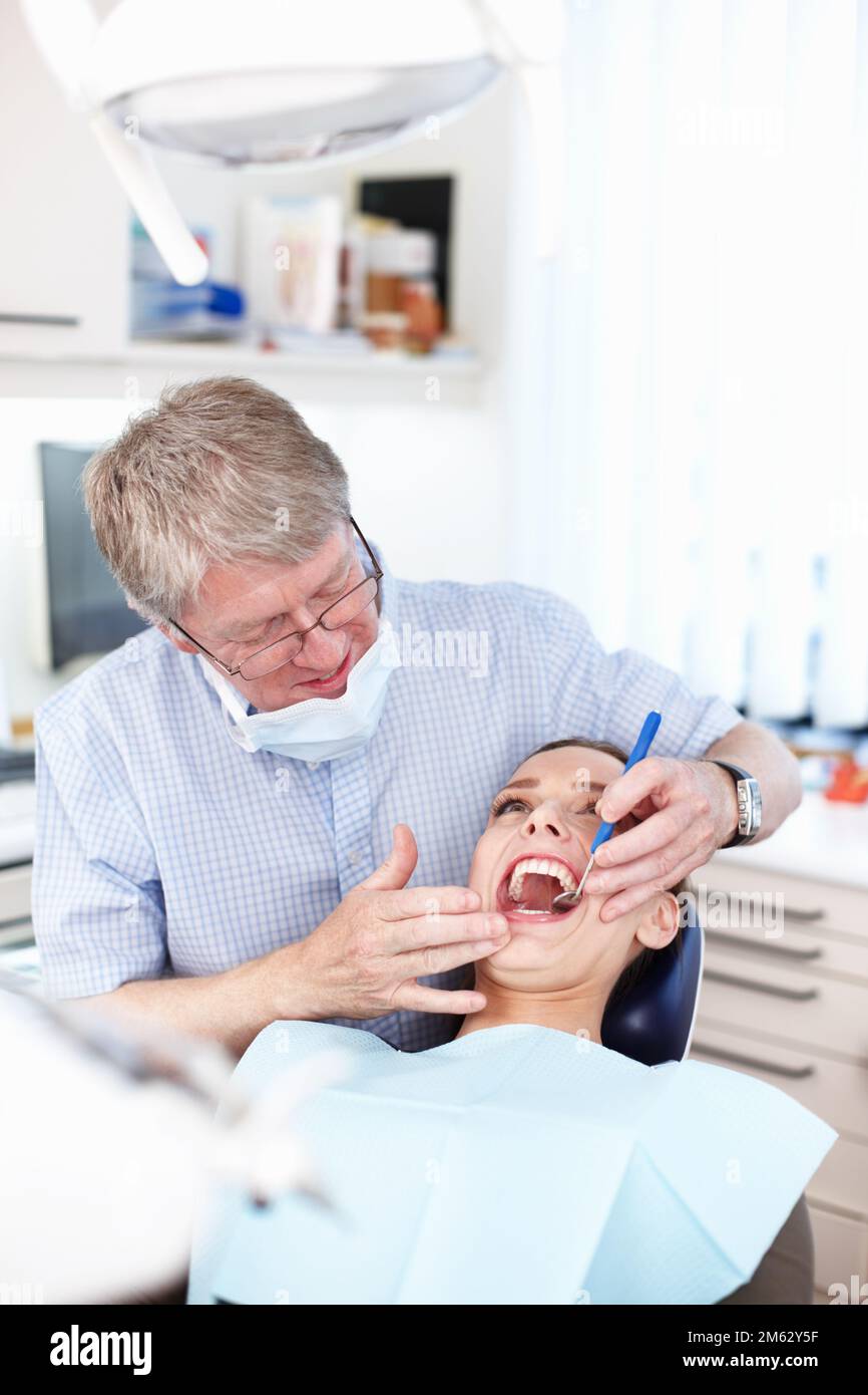 Visita di controllo. Ritratto del dentista maschio che controlla i denti del paziente. Foto Stock