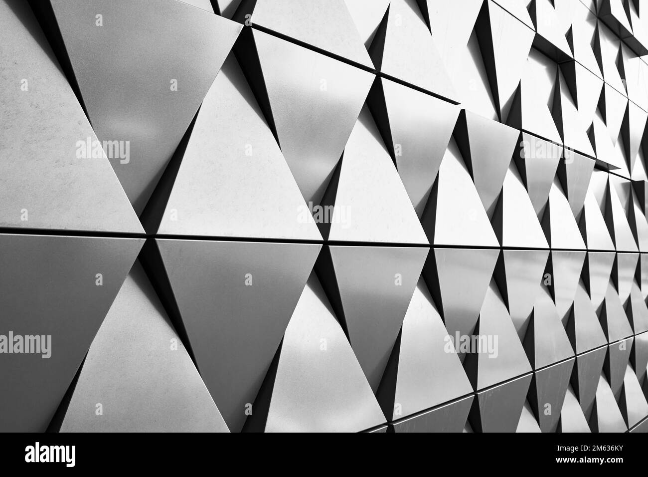 Parete in argento con elementi a triangolo dalle forme geometriche. Schema dei dettagli dell'architettura astratta. Sfondo astratto minimo Foto Stock