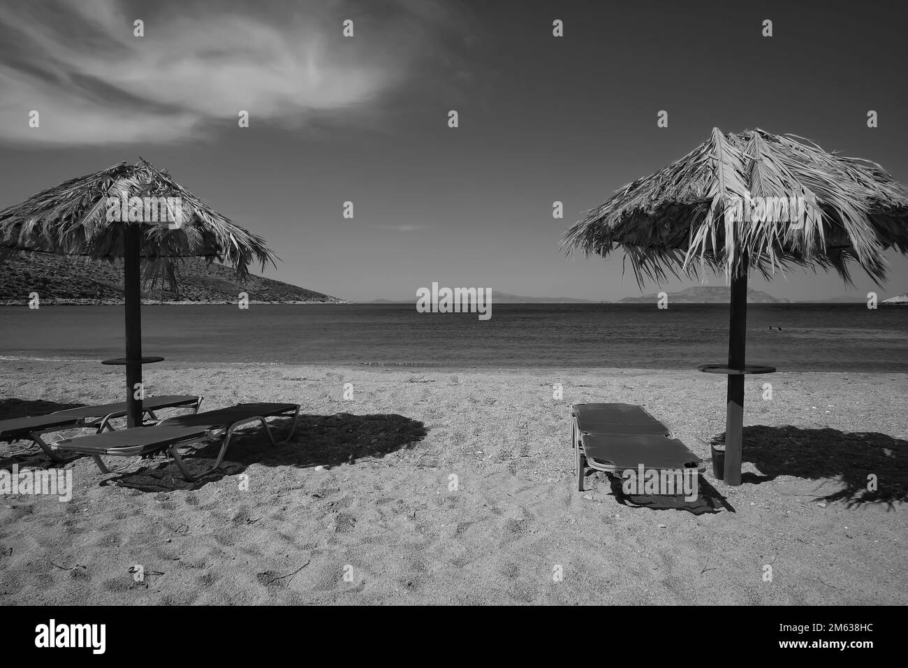 Lettini e ombrelloni sulla splendida spiaggia di Agia Theodoti in iOS Grecia in bianco e nero Foto Stock