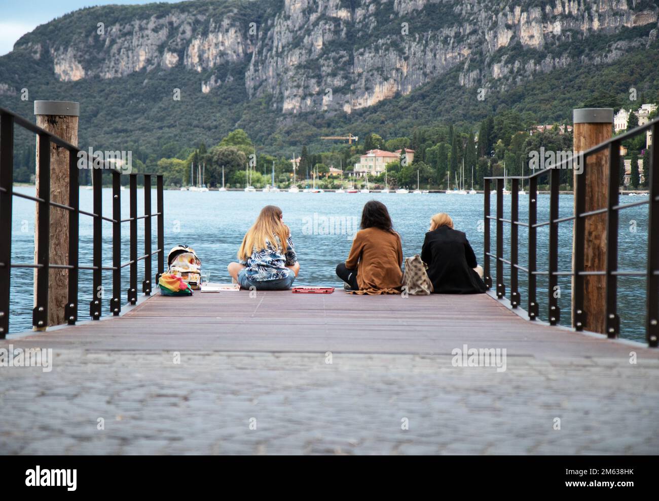 i turisti ai margini del porto guardano al lago Foto Stock