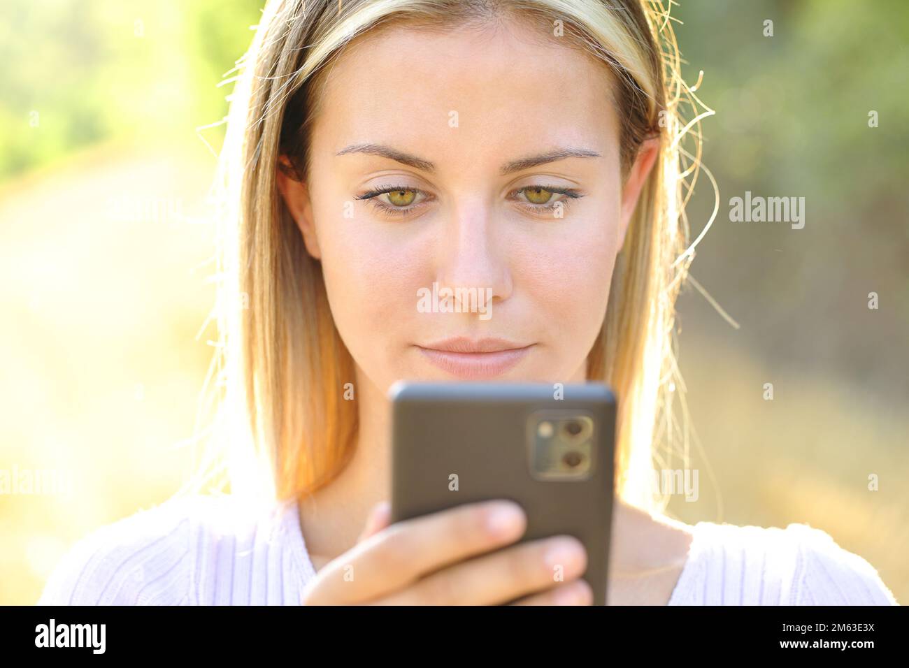 Immagine frontale di un adolescente che utilizza lo smartphone in natura Foto Stock