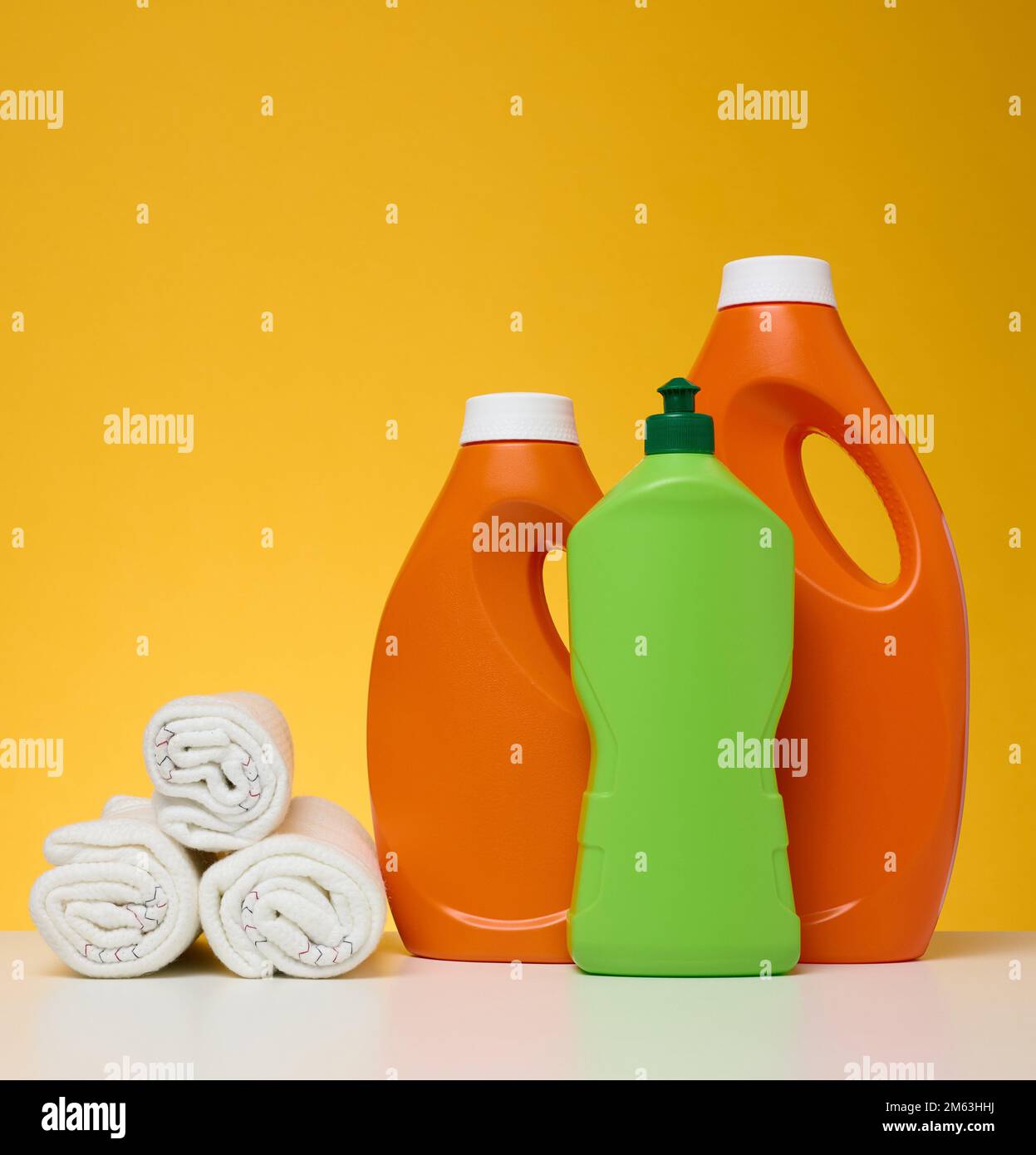 Stracci ritorti per la pulizia di pavimenti e bottiglie di plastica per  prodotti chimici liquidi, gel, detergente su tavolo bianco, fondo giallo  Foto stock - Alamy