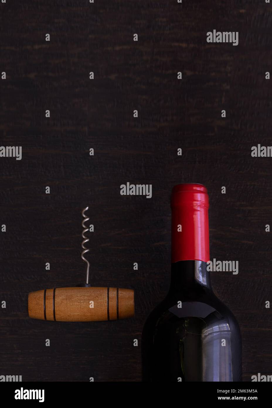 Bottiglia di vino rosso con cavatappi di tavola in legno. Fondo concetto amanti del vino. Foto Stock