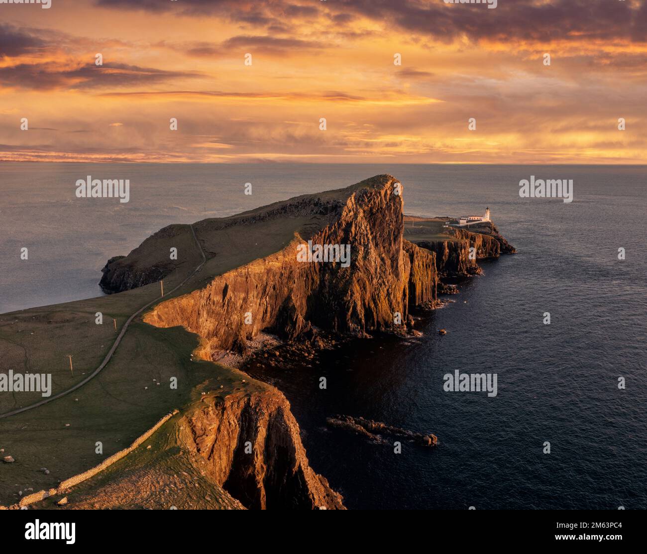 Isola di Skye nelle Highlands scozzesi, faro di Neist Point, affioramento nell'Oceano Atlantico. Vista aerea al tramonto guardando il faro Foto Stock