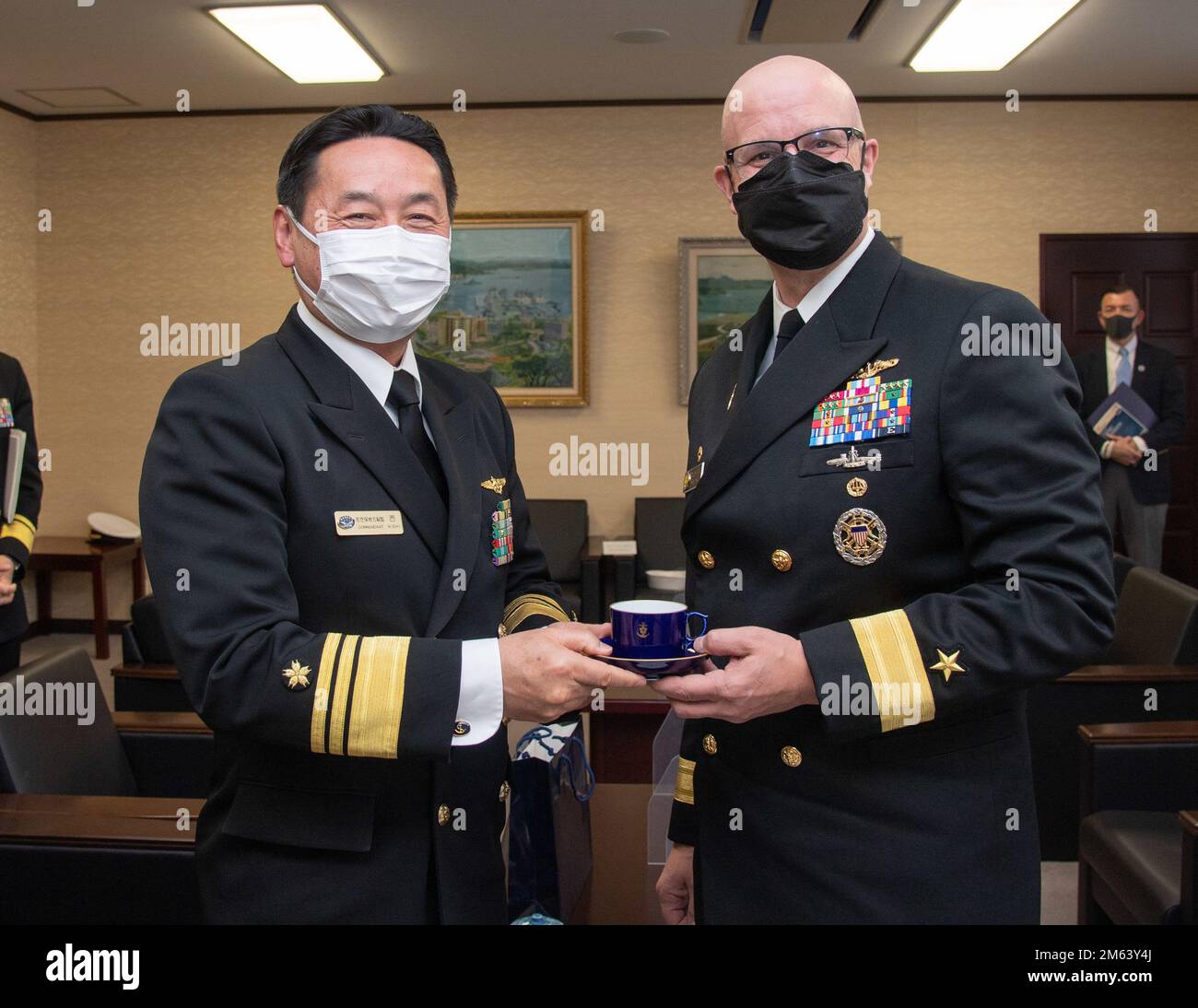 Modulo posteriore Carl Lahti, Commander, Navy Region Giappone/ Commander, USA Forze navali Giappone, riceve un regalo dal vice ammiraglio Naruto Nishi, comandante, distretto di JMSDF Sasebo, nella sede centrale del distretto di JMSDF Sasebo, 30 marzo 2022. Lahti ha incontrato i leader della Sasebo City, Saikai City e della forza di autodifesa marittima giapponese nel quadro di una visita programmata al CFAS per acquisire familiarità con l'installazione e l'area locale. Foto Stock