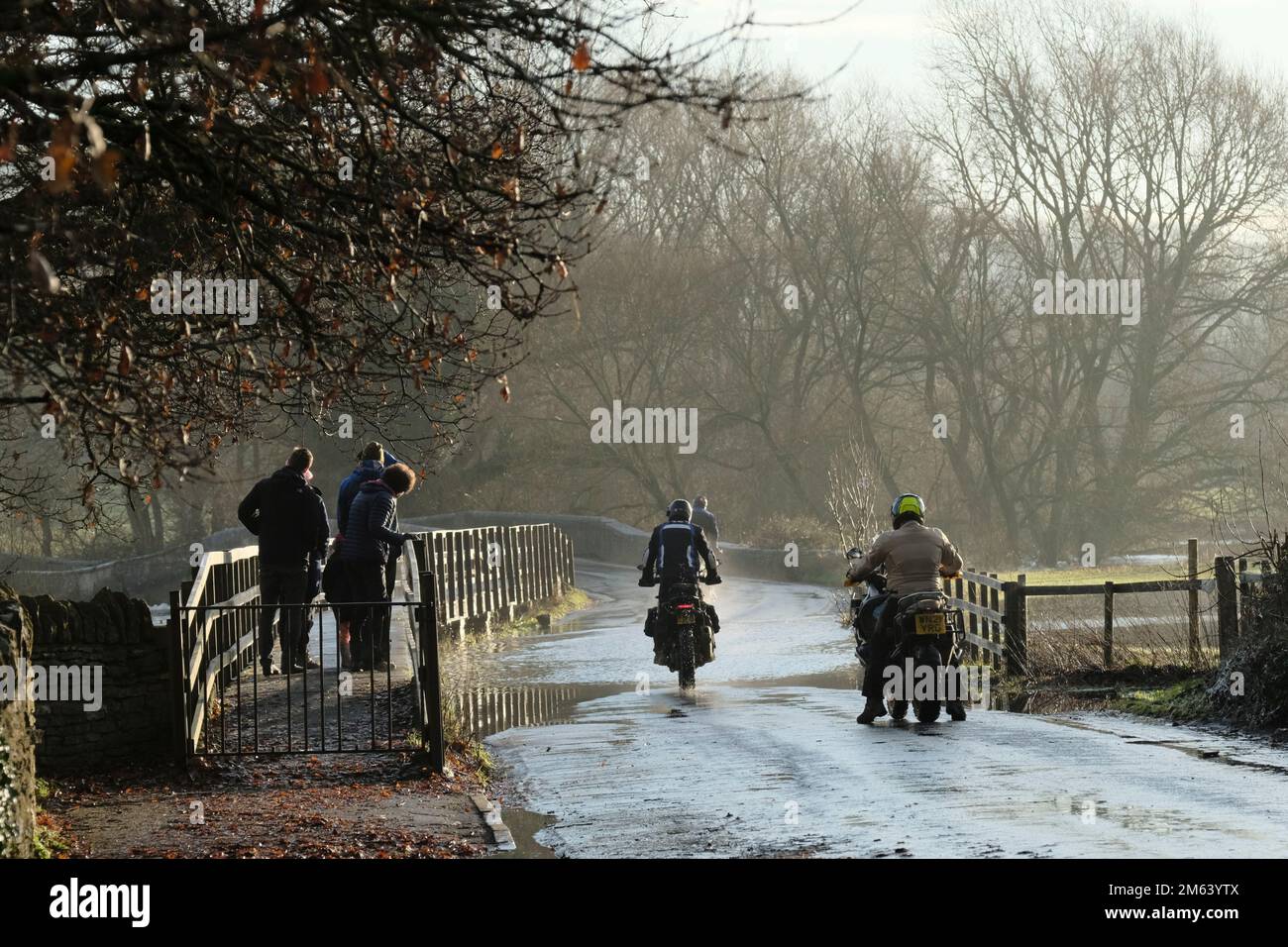 Lacock, Wiltshire, Regno Unito. 2nd Jan, 2023. Il fiume Avon a Lacock ha allagato la strada fuori dal villaggio. I cartelli stradali chiusi sono in alto ma la strada è percorribile con cautela. Alcuni bikers provano i loro caricamenti del sistema per le perdite. Credit: JMF News/Alamy Live News Foto Stock