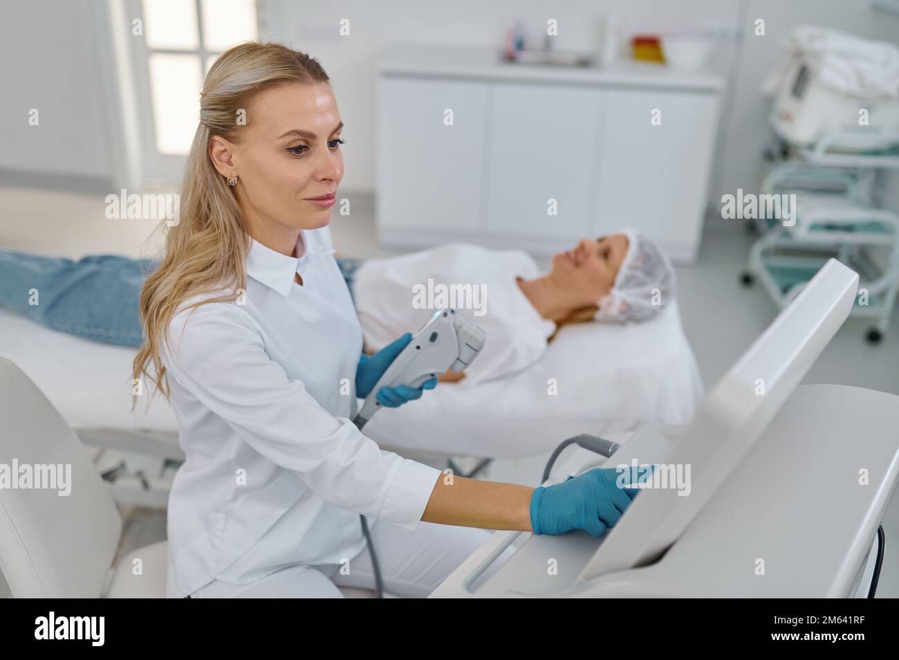 Ritratto di giovane cosmetologo che tiene attrezzature per la rimozione dei capelli laser Foto Stock