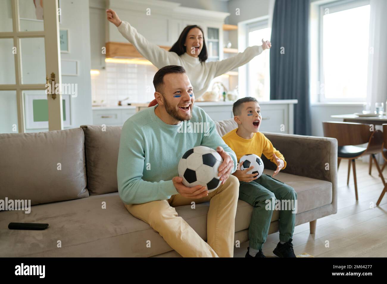 Genitore eccitato con bambino overjoyed che guarda la partita di calcio in tv a casa Foto Stock