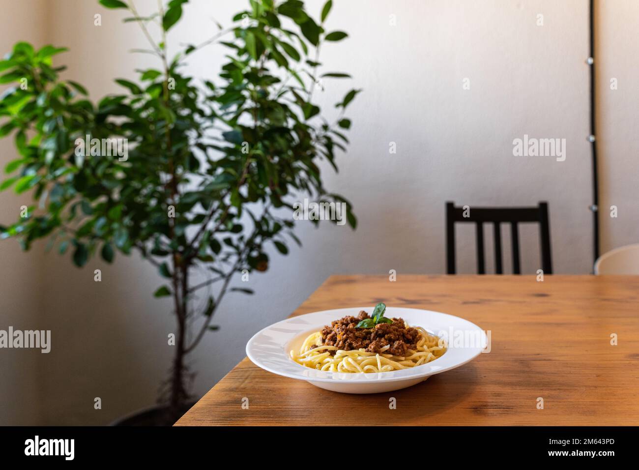 Spaghetti bolognesi in un piatto bianco su un tavolo di legno. Un piatto classico di cucina italiana. Foto Stock