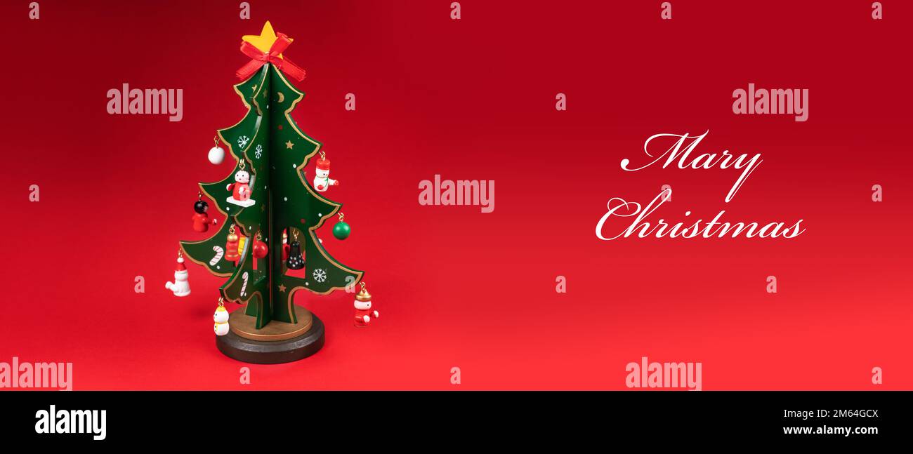 Miniatura modello Inverno Pino albero con neve è puntelli decorazione per creare un'atmosfera festival Natale. su sfondo rosso Foto Stock