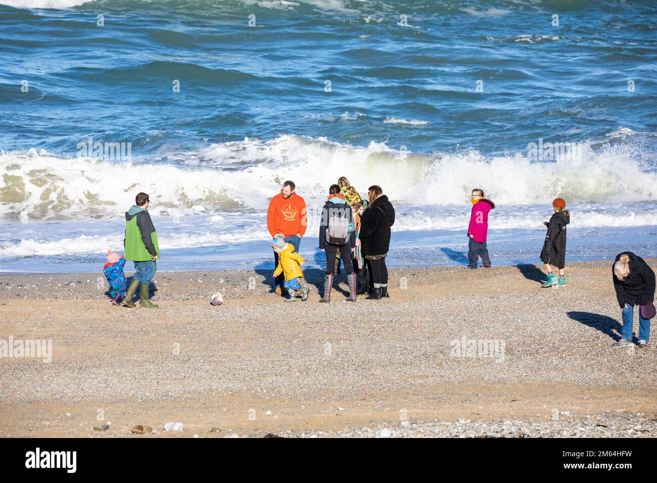 Portreath, Cornovaglia, 2nd gennaio 2023, la gente era fuori per una passeggiata mattutina sulla spiaggia durante l'alta marea a Portreath, Cornovaglia. Il cielo era blu con sole glorioso e 8C, la previsione dopo oggi è per il tempo bagnato per i prossimi giorni. La petroliera Maersk Bering è stata ancorata appena al largo della riva, il che è molto insolito.Credit: Keith Larby/Alamy Live News Foto Stock