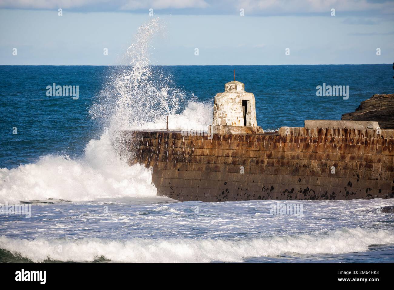 Portreath, Cornovaglia, 2nd gennaio 2023, la gente era fuori per una passeggiata mattutina sulla spiaggia durante l'alta marea a Portreath, Cornovaglia. Il cielo era blu con sole glorioso e 8C, la previsione dopo oggi è per il tempo bagnato per i prossimi giorni. La petroliera Maersk Bering è stata ancorata appena al largo della riva, il che è molto insolito.Credit: Keith Larby/Alamy Live News Foto Stock