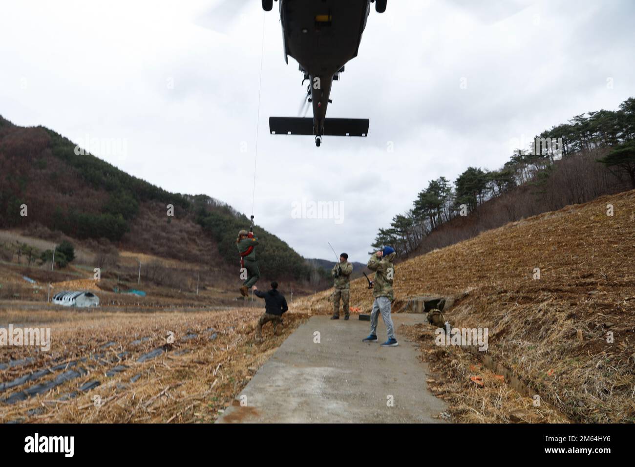 STATI UNITI Air Force 1st Lt. Peyton Wilkie, un HH-60 Pave Hawk Helicopter Pilot assegnato al 33rd Rescue Squadron, Osan Air base, agisce come una "persona isolata" che viene issata in un elicottero ad ala rotante durante una Joint Combat Search and Rescue Mission, Pyeongchang, Repubblica di Corea, 31 marzo 2022. I piloti e gli istruttori DI SERE hanno contribuito a garantire che l'operazione sia stata eseguita correttamente per garantire l'estrazione sicura della persona isolata. Foto Stock