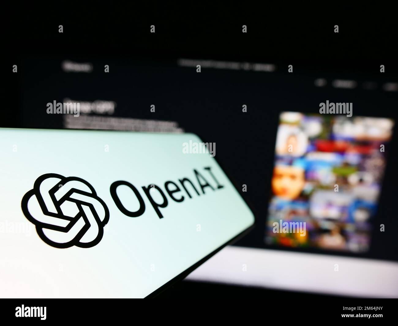 Cellulare con logo della società americana di intelligenza artificiale OpenAI LLC sullo schermo di fronte al sito web aziendale. Messa a fuoco a sinistra del display del telefono. Foto Stock