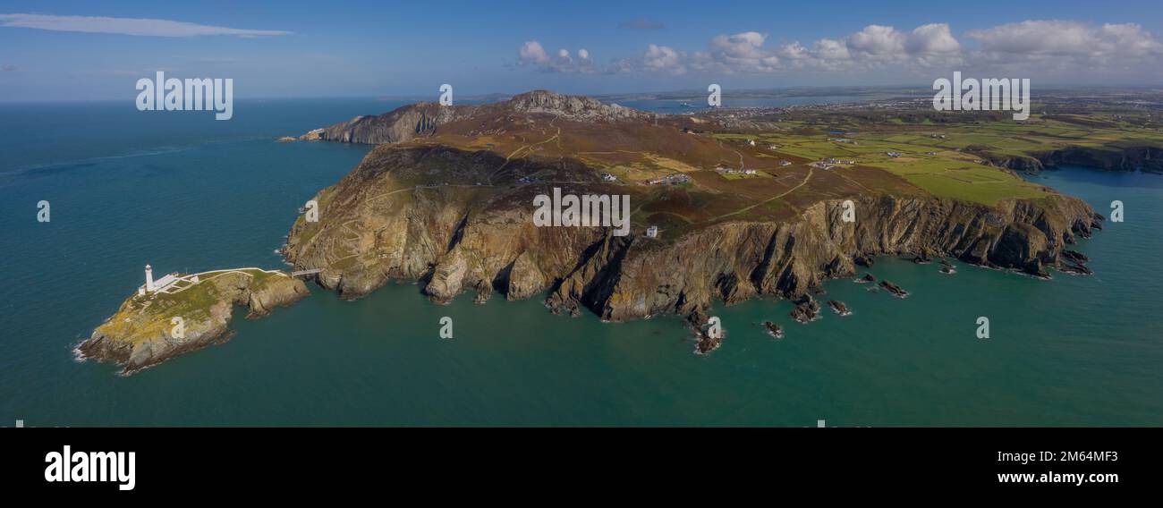 Foto panoramica del faro di South Stack vicino all'antenna di Holyhead Anglesey, scattata dal mare, che mostra l'isola e le scogliere rocciose Foto Stock