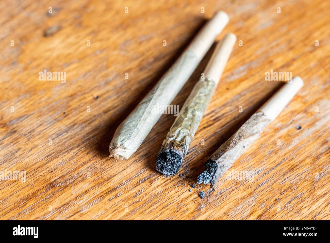 Sigaretta di cannabis nuova e spesa su un tavolo di legno Foto Stock