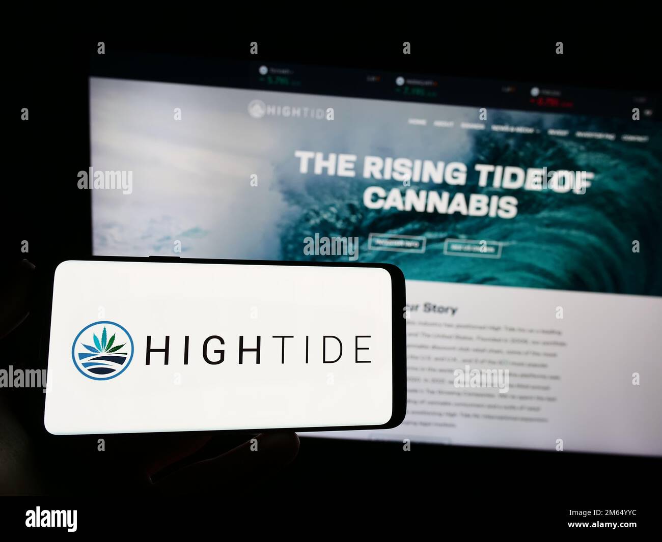 Persona che tiene uno smartphone con il logo della società canadese di cannabis High Tide Inc. Sullo schermo di fronte al sito web. Messa a fuoco sul display del telefono. Foto Stock