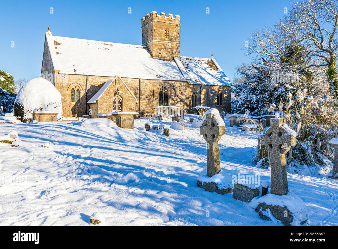 Neve d'inverno all'inizio della chiesa di St Michael & All Angels del 12th ° secolo nel villaggio di Cotswold di Bridpsfield, Gloucestershire, Inghilterra UK Foto Stock