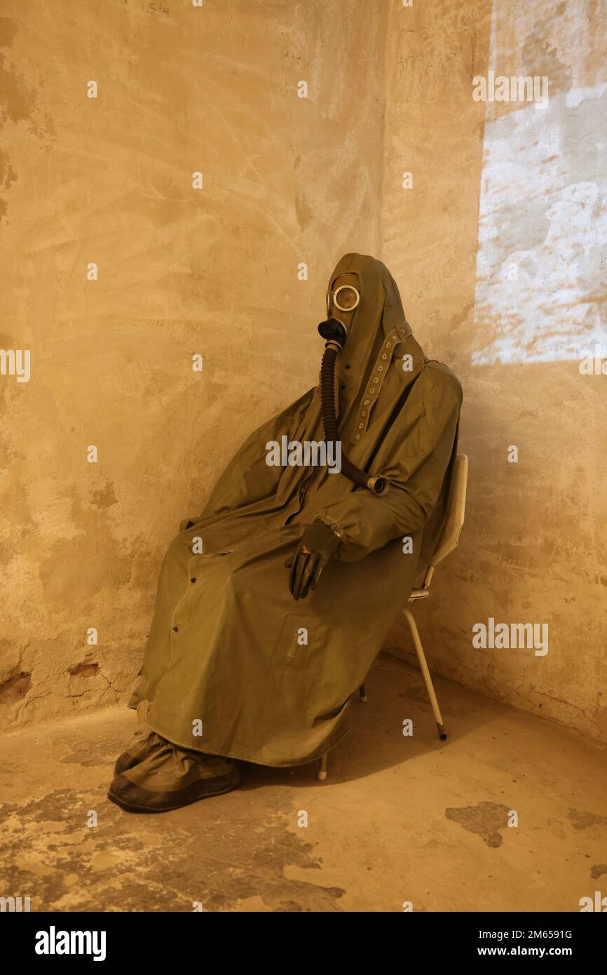 Figura seduta in abiti protettivi, tra cui maschera a gas del periodo della Guerra fredda, come esposto nel museo Nowa Huta di Cracovia, Polonia Foto Stock