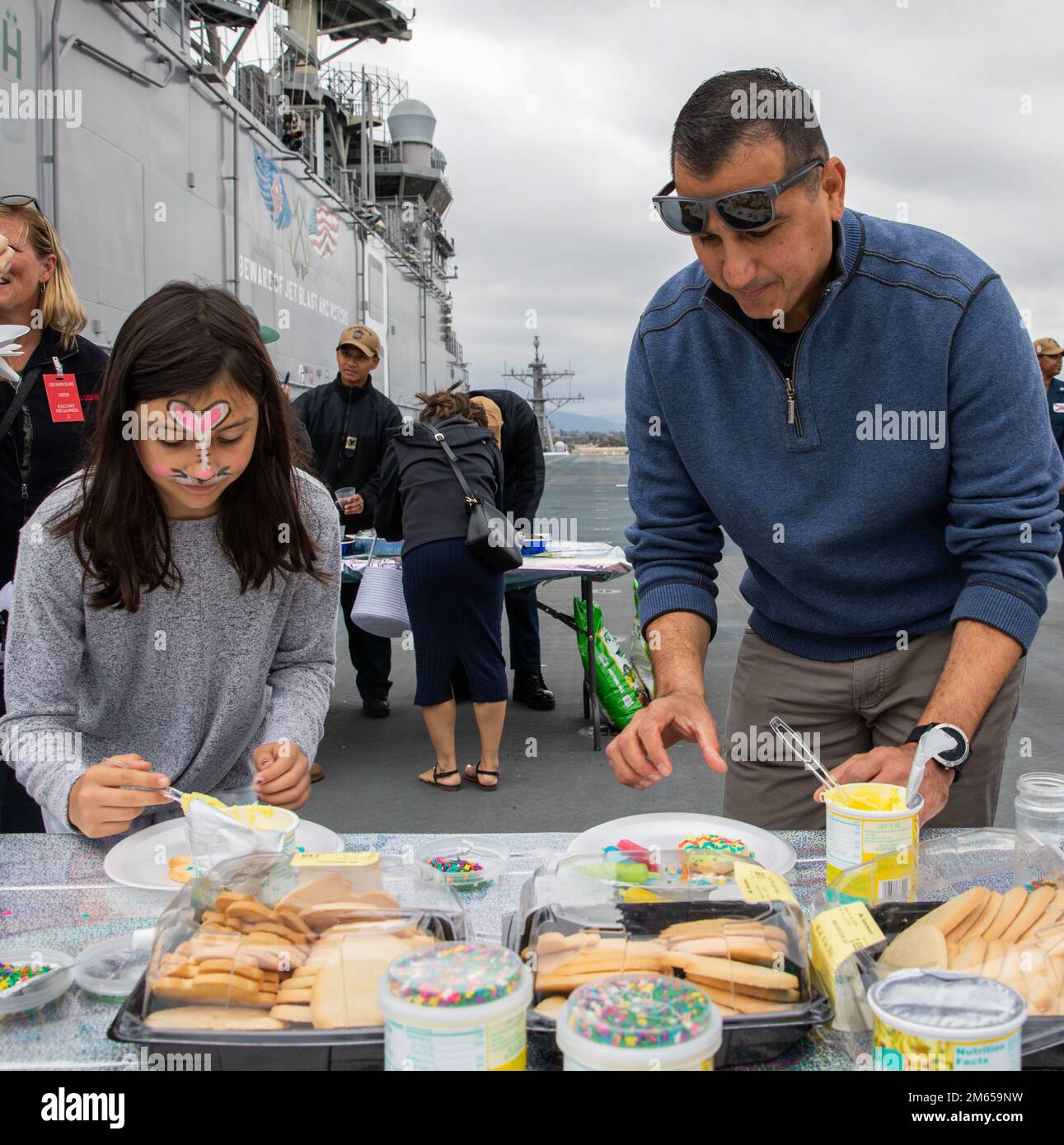 220403-N-XK047-1058 SAN DIEGO (3 aprile 2022) – il capitano Tony Chavez, comandante della nave d'assalto anfibia USS Makin Island (LHD 8), decora i biscotti durante un Command Family Fun Day sul ponte aereo di Makin Island, il 3 aprile. Il morale, il benessere e il tempo libero di Makin Island (MWR) ha ospitato l'evento con il sostegno della First Class Petty Officer Association (FCPOA), della Second Class Petty Officer Association (SCPOA) e della Junior Enlisted Association (JEA). Makin Island è una nave d'assalto anfibio di classe Wasp ospita a San Diego. Foto Stock