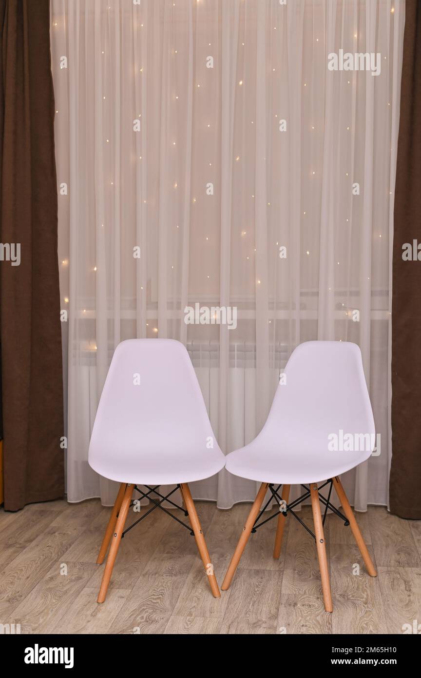 due sedie bianche sullo sfondo delle tende. interni domestici Foto Stock