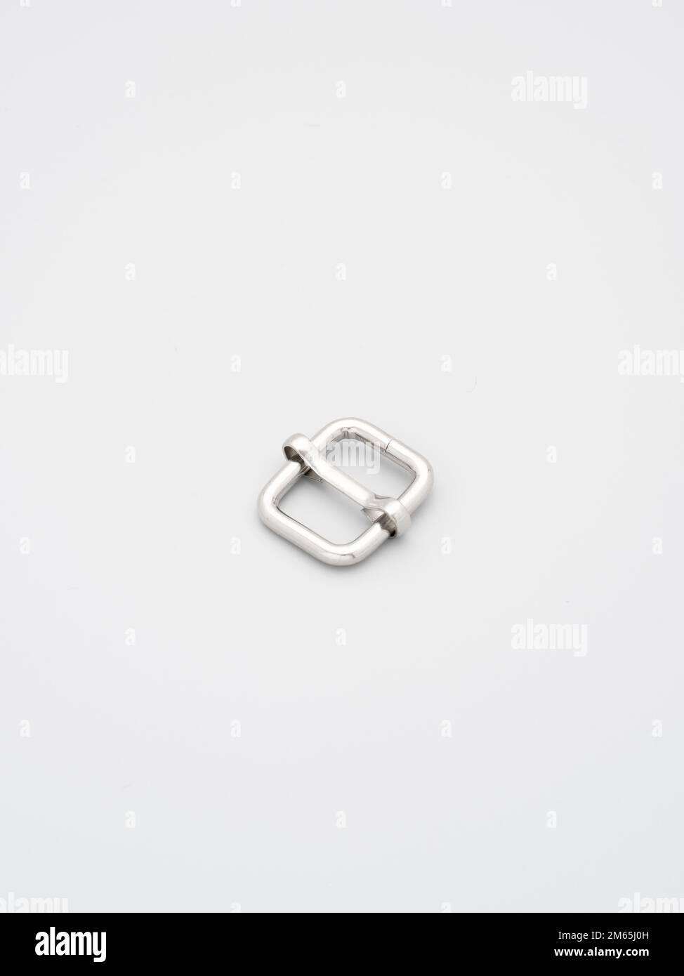 Metallo c e telai per la produzione di borse e zaini su sfondo grigio. Cornici in metallo cromato per tracolle borse. Accessorio per cucire, realizzazione sacchetti Foto Stock
