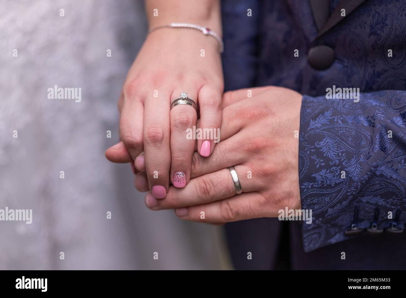 Primo piano delle mani di una coppia sposata appena sposata con anelli di nozze. Foto Stock