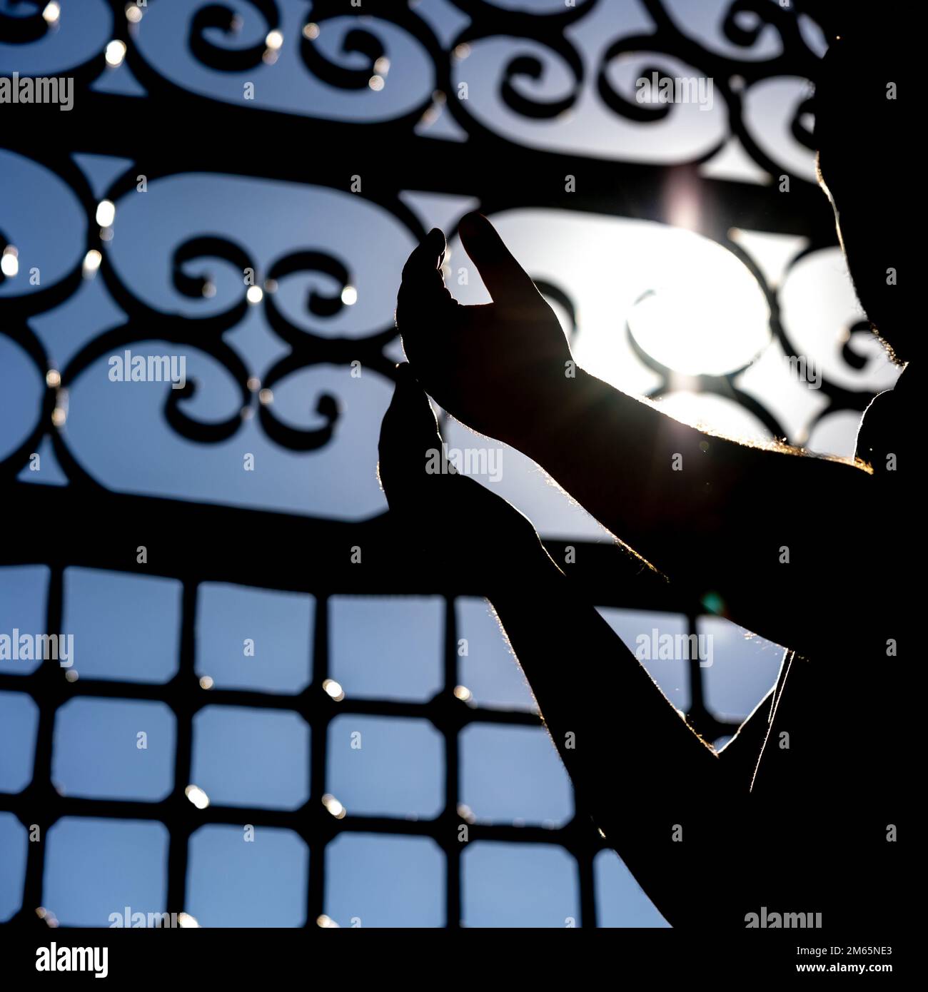 Foto di concetto islamico in formato quadrato. Silhouette di un uomo musulmano mentre prega. Foto di sfondo Ramadan o islamica. Foto Stock
