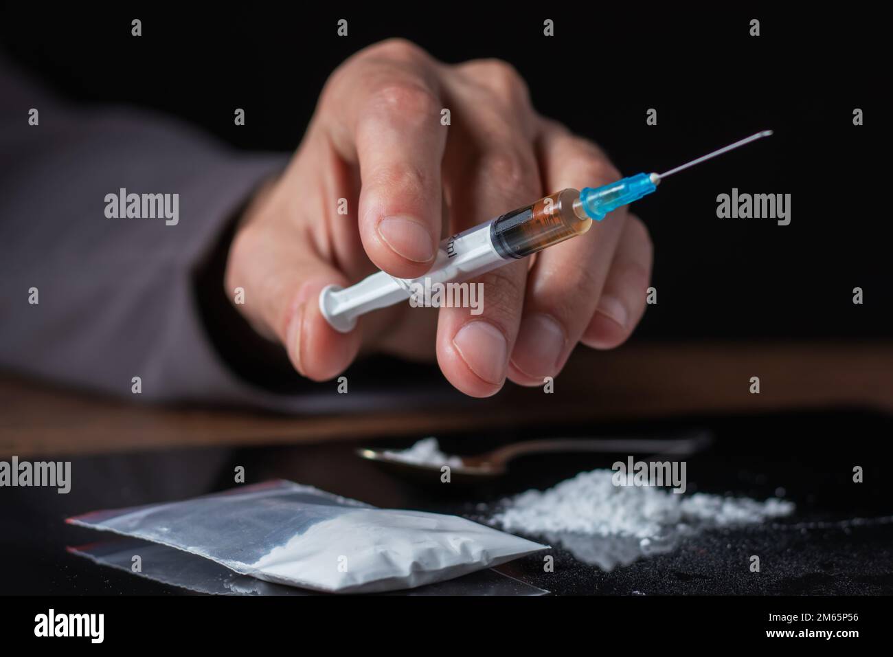 Siringa del farmaco in mano. Un tossicodipendente con un'altra dose del farmaco nella siringa. Guy dipendente, il concetto di anti-droga. tossicodipendente maschile. Foto Stock
