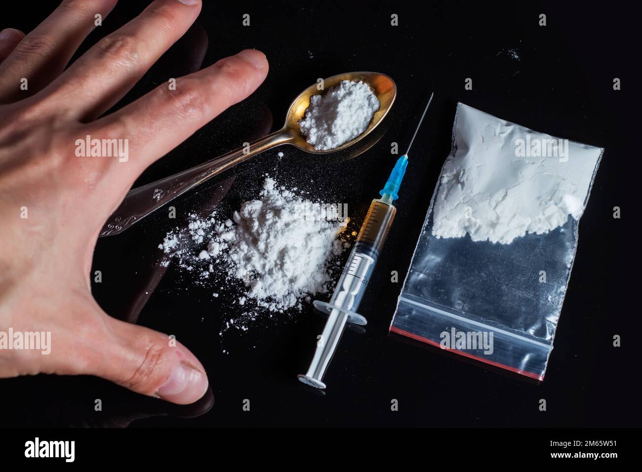 Il concetto di anti-droga. Il tossicodipendente raggiunge un'altra dose del farmaco nella siringa. Ragazzo addicted, tossicodipendente maschile, siringa di droga Foto Stock