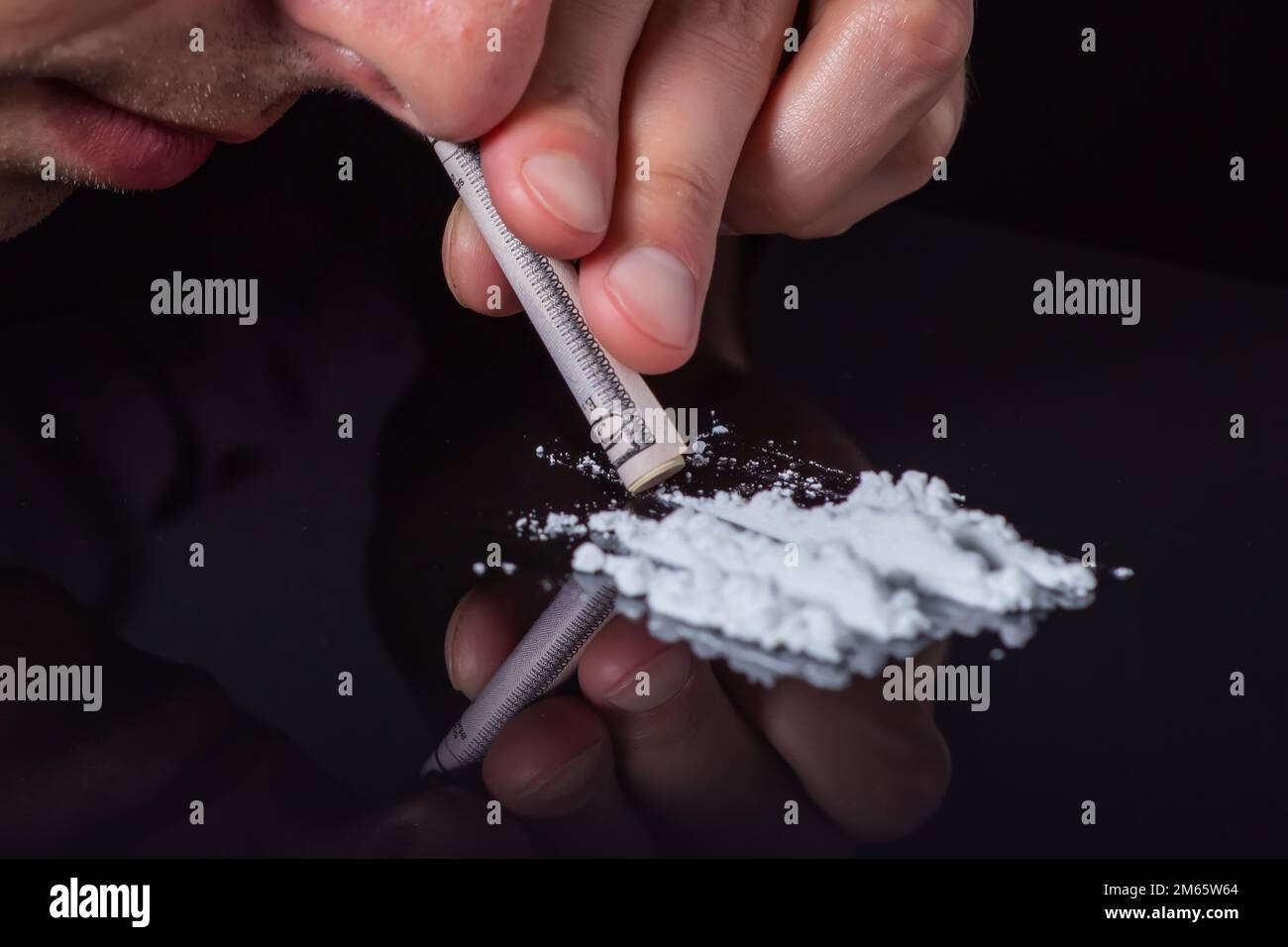 Concetto di tossicodipendenza.. Abuso di droghe, uomo che prende droghe, linee di russare di polvere di cocaina, primo piano. Foto Stock