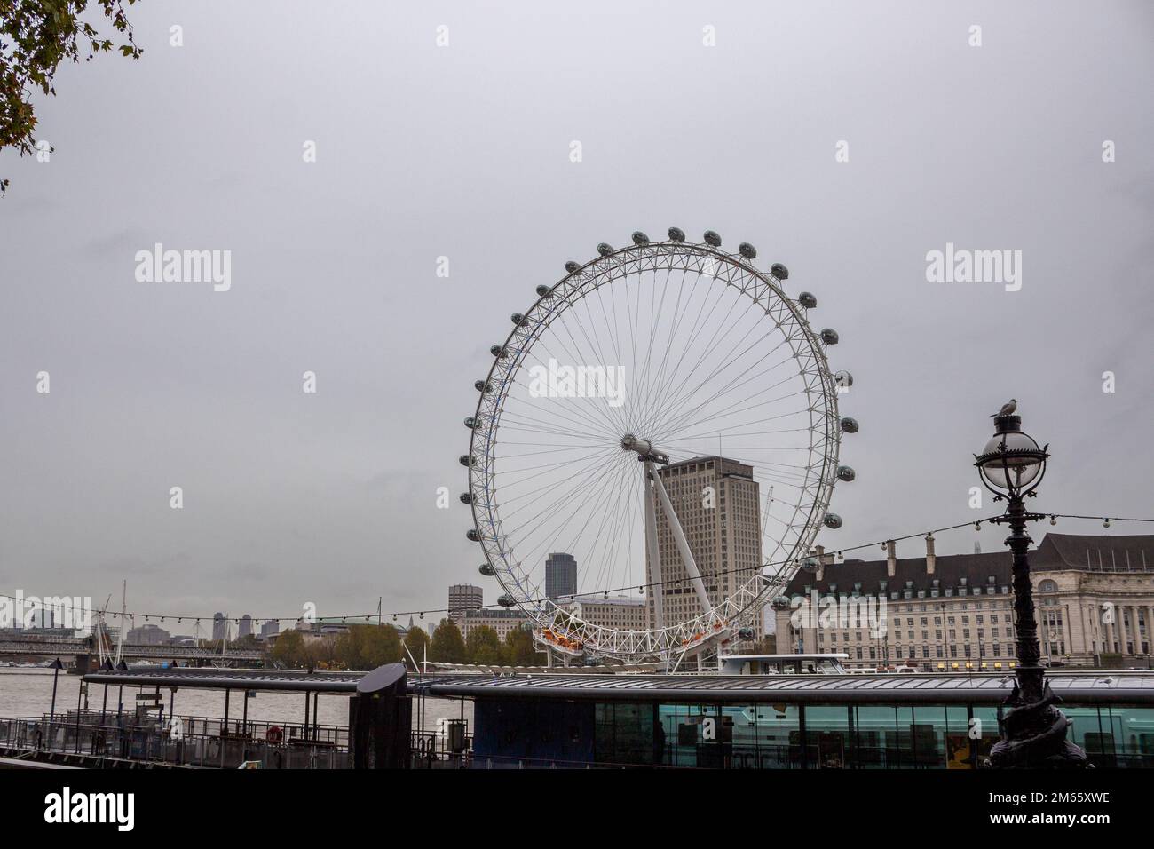 Il London Eye in una giornata di pioggia sul Tamigi a Londra, Inghilterra Foto Stock