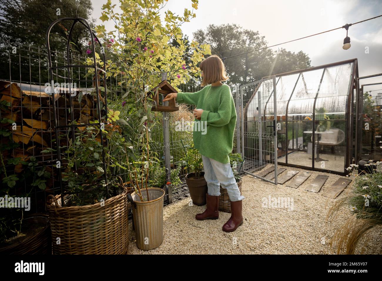 Donna nutrire gli uccelli nel cortile Foto Stock